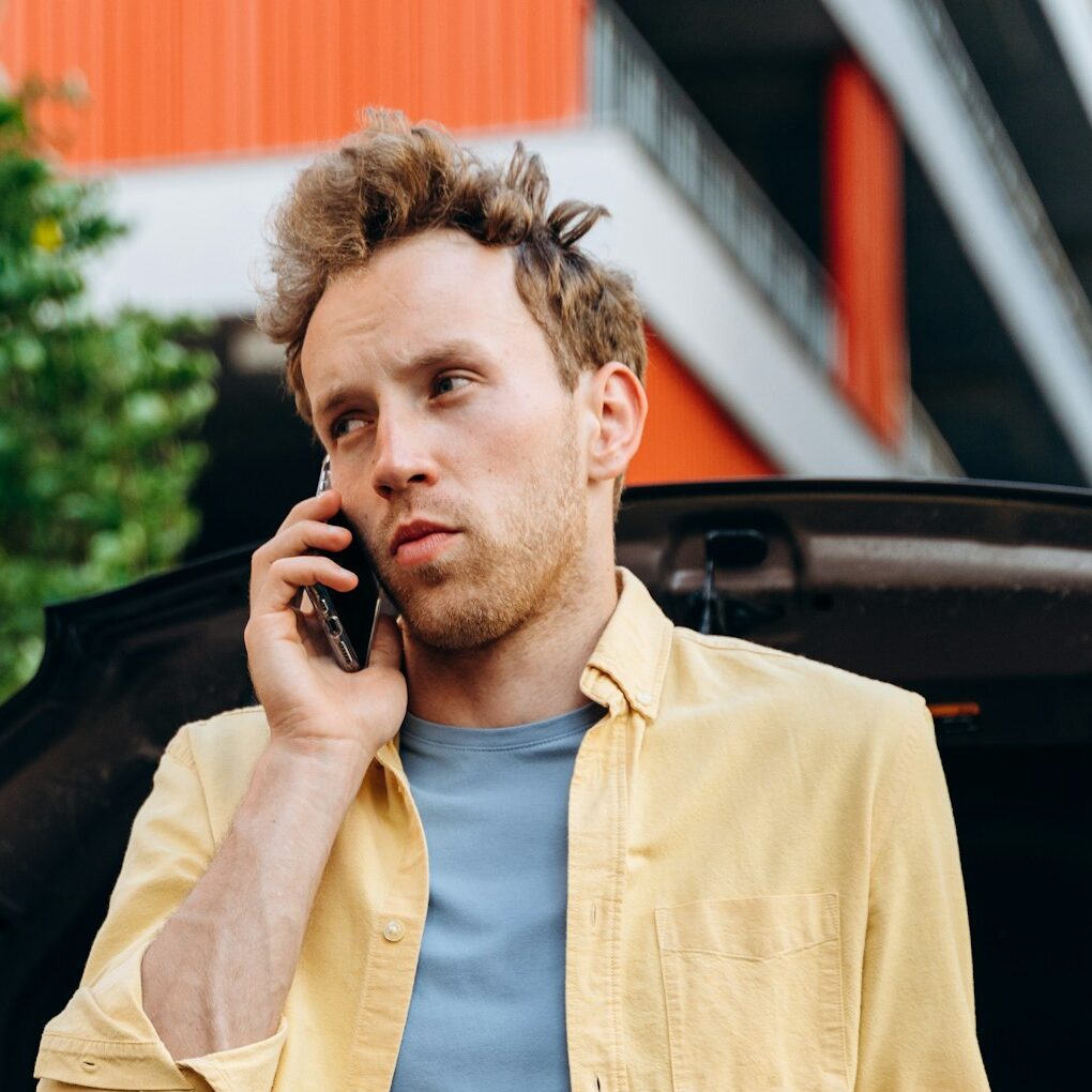 Handsome man making a telephone call to fix the car.